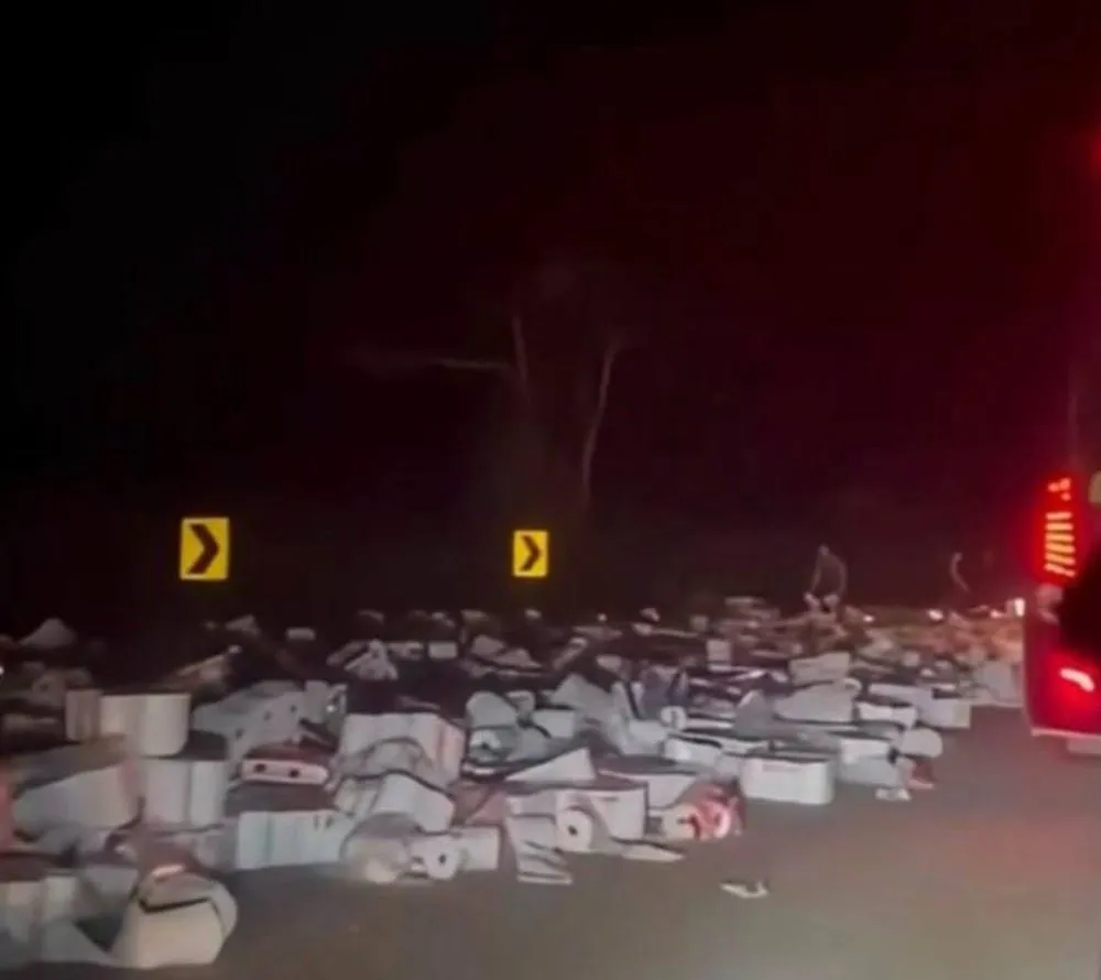 Carga de caminhão se espalha pela pista e moradores surpreendem com atitude